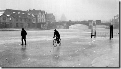 People cycle and walk along a frozen River Thames in London. Credit PA