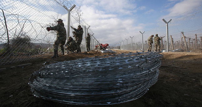 Macedonian army soldiers erect a second fence on the border line with Greece, near the southern Macedonia's town of Gevgelija, Monday, Feb. 8, 2016. Macedonia started reinforcing the border fence with Greece, doubling it with another fence, which is expected to increase the control of the migrant flow. European Union nations anxious to stem the flow of asylum-seekers coming through the Balkans are increasingly considering sending more help to non-member Macedonia as a better way to protect European borders instead of relying on EU member Greece. (AP Photo/Boris Grdanoski)